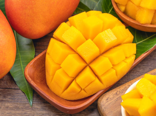 istock Fresh chopped mango cubes on wooden cutting board and rustic timber background. Tropical summer fruit concept, close up, macro, copy space. 1162986904