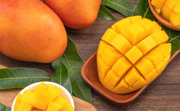 istock Fresh chopped mango cubes on wooden cutting board and rustic timber background. Tropical summer fruit concept, close up, macro, copy space. 1162986906