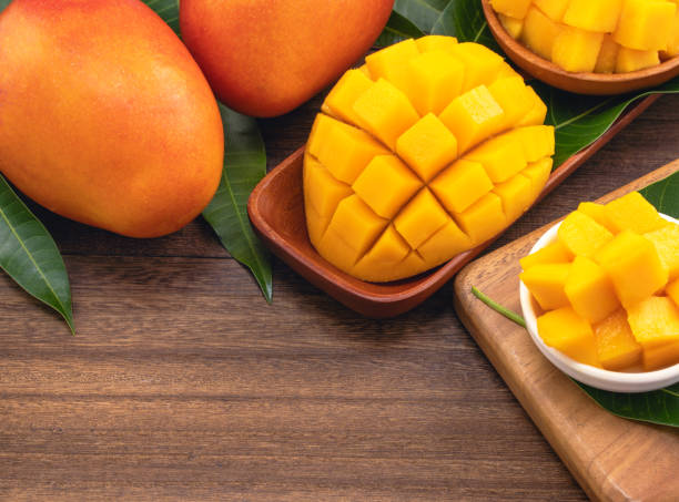 istock Fresh chopped mango cubes on wooden cutting board and rustic timber background. Tropical summer fruit concept, close up, macro, copy space. 1162986907
