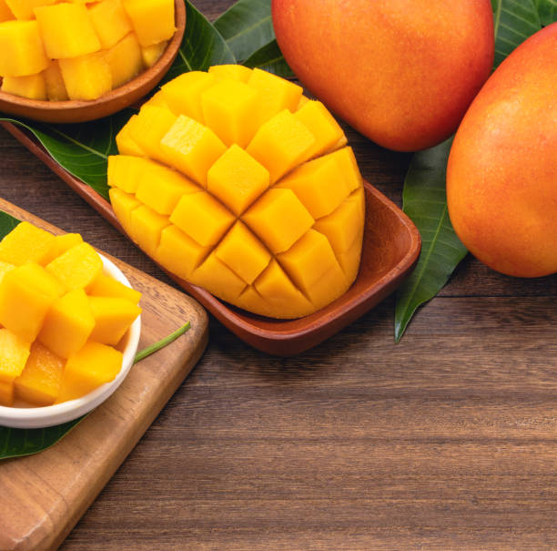 istock Fresh chopped mango cubes on wooden cutting board and rustic timber background. Tropical summer fruit concept, close up, macro, copy space. 1162986910