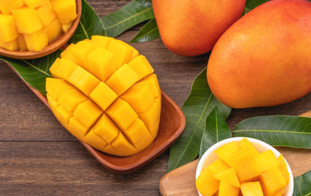 istock Fresh chopped mango cubes on wooden cutting board and rustic timber background. Tropical summer fruit concept, close up, macro, copy space. 1162986936