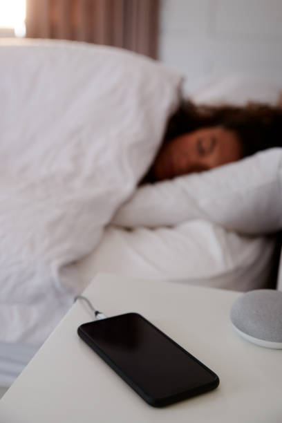 istock Woman Asleep In Bed With Mobile Phone On Bedside Table 1162987055