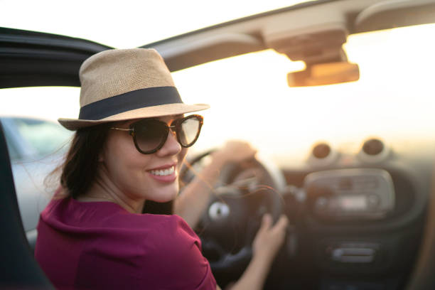 istock Woman looking over shoulder and driving car 1162987991