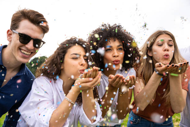istock Friends having fun outdoors in a park playing with confetti 1162988053