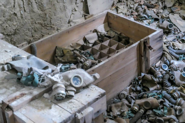 A pile of gas masks spreading all over the floor, left to decay in one of the building abandoned after the nuclear explosion in Chernobyl. Other unidentifiable objects are decaying between the masks.