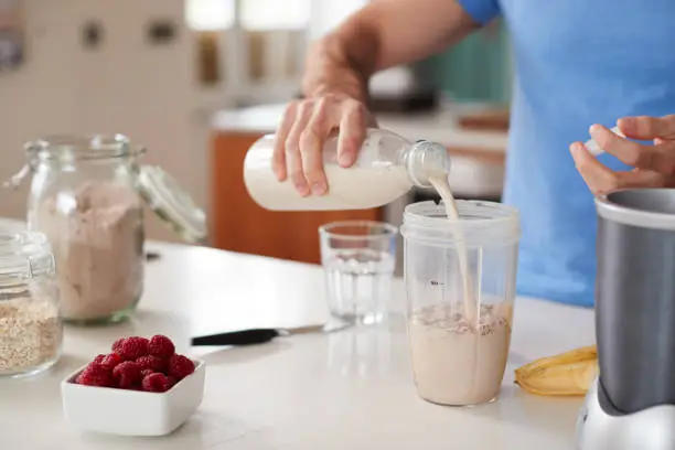 Photo of Close Up Of Man Making Protein Shake After Exercise At Home