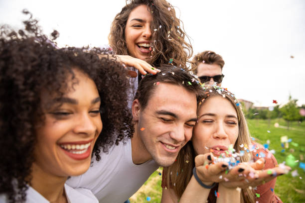 istock Friends having fun outdoors in a park playing with confetti 1162988527