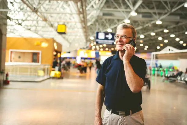 Man at airport using cell phone