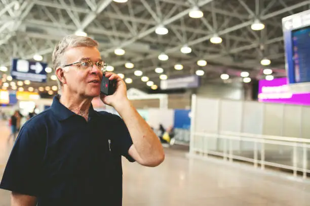 Man at airport using cell phone