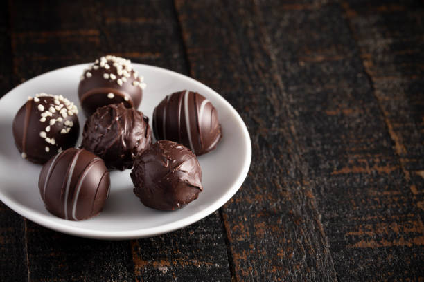 A Moody Image of Chocolate Truffles on a Rustic Wooden Table
