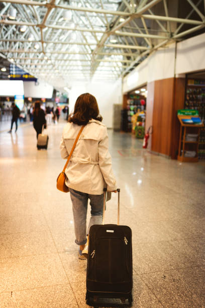 istock Woman at airport wit a suitcase 1162991888