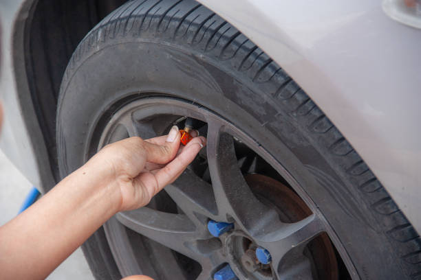 istock Woman's hands fill the car tire with a simple matter. Security Czech 1162991961