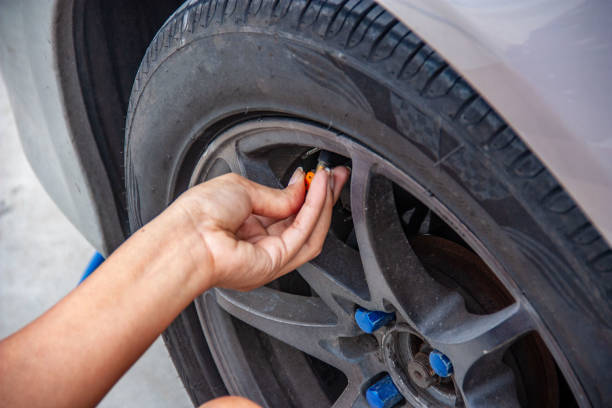 istock Woman's hands fill the car tire with a simple matter. Security Czech 1162991962