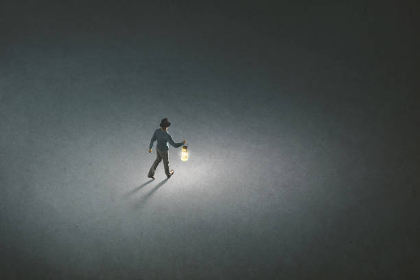 istock lonely man with torch light walking illuminating his path 1162992330
