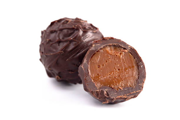 truffes au chocolat noir remplies de caramel d'isolement sur un backgroun blanc - praline photos et images de collection
