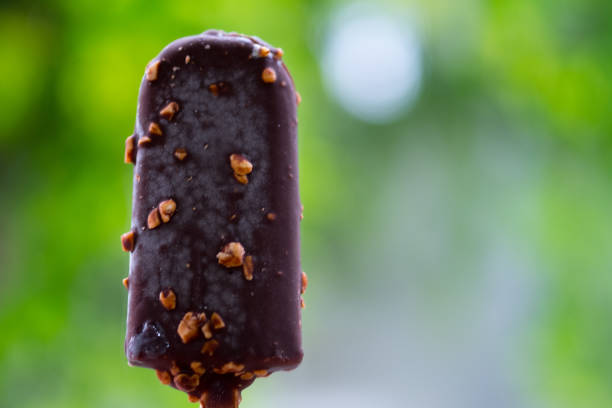 istock Ice cream bar - vanilla covered with chocolate and almonds with nature background 1162994213