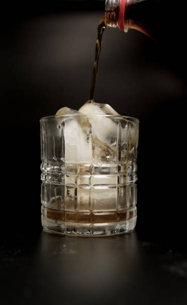 istock Pouring refreshing cola into glass with ice cubes 1162994859