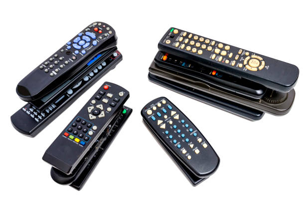 Horizontal shot of four stacks of old remote controls. White background.