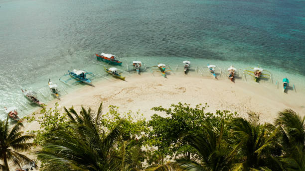 istock Tropical Guyam Island with a sandy beach and tourists 1163000171
