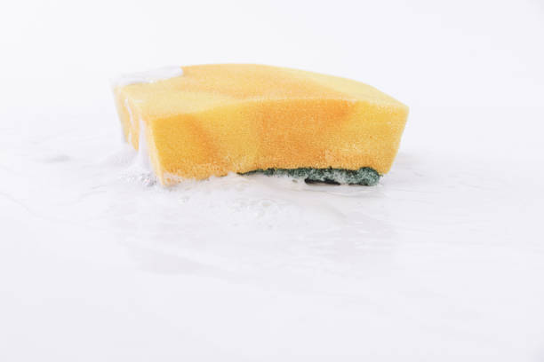 Dish-washing sponge with detergent and foam on white background