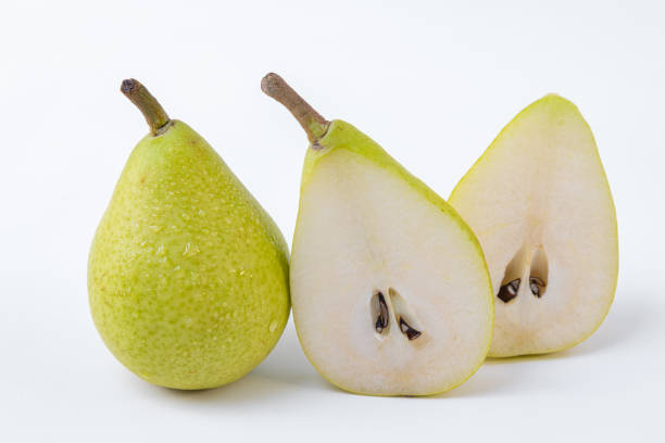 istock A pear in two halves accompanied by a whole pear isolated on a white background - Green and sweet pears 1163000412