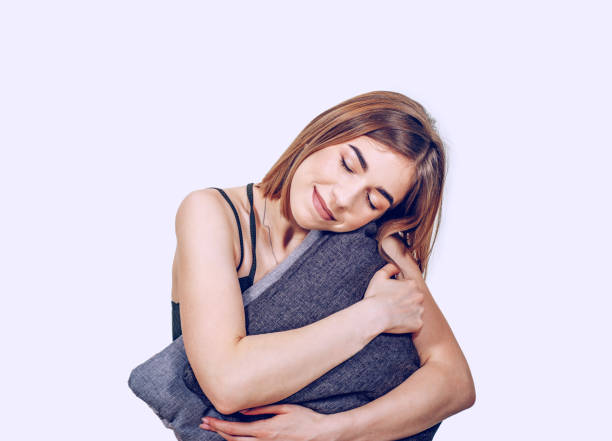 istock Relaxed girl hugging pillows while sitting on the floor. Sleep, relaxation, rest 1163001645