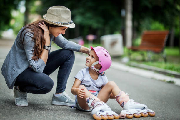 istock Smiling mother assisting her little girl in rollerblading 1163002962