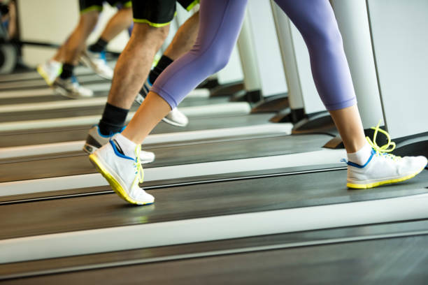istock Woman and man jogging on treadmills 1163005105