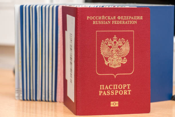 istock Russian biometric passport against other documents during border control. Inscription - Russian Federation. Passport. Close-up 1163005659