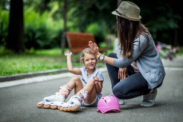 istock Smiling mother assisting her little girl in rollerblading 1163006941