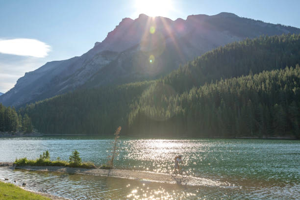 istock Mountain biker rides along sandy spit in mountain lake 1163008685