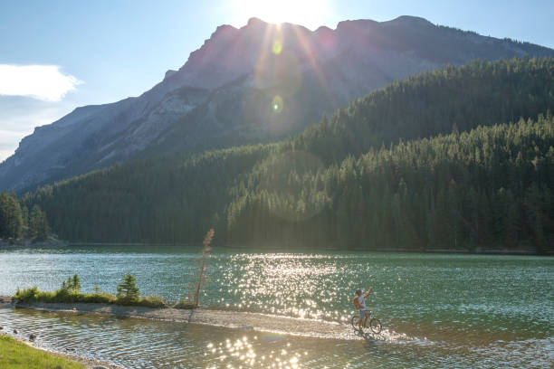istock Mountain biker rides along sandy spit in mountain lake 1163008687