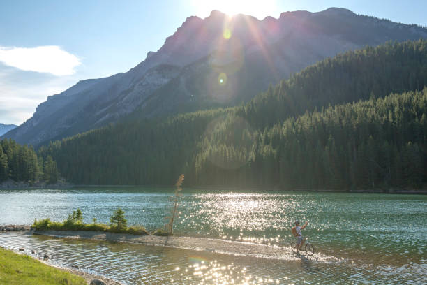 istock Mountain biker rides along sandy spit in mountain lake 1163008883
