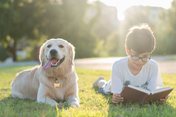 Schoolboy reading book with her dog