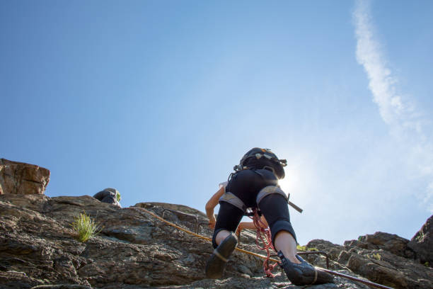 alpiniści udają się w górę skalnej twarzy - mountain climbing rock climbing motivation awe zdjęcia i obrazy z banku zdjęć