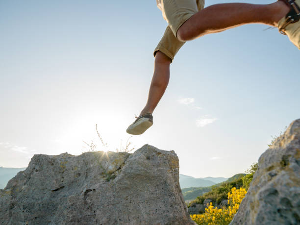 istock Hiker jumps onto rock at sunrise 1163010868