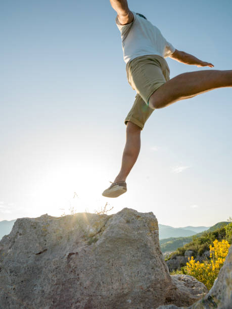 istock Hiker jumps onto rock at sunrise 1163010913
