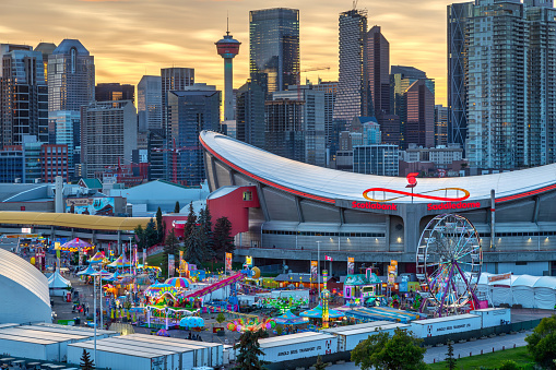 Sunset over Calgary skyline with the annual Stampede event at the Saddledome grounds. The Calgary Stampede is renowned as the greatest outdoor show on Earth.
