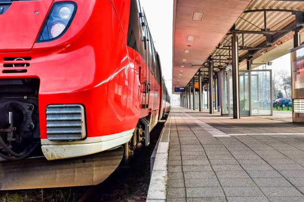 um trem vermelho está esperando em uma plataforma vazia para a partida - mass transport - fotografias e filmes do acervo