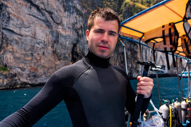 männliche taucher halten action-kamera und vorbereitung für das tauchen, phi phi island - oxygen tank underwater diving diving wetsuit stock-fotos und bilder