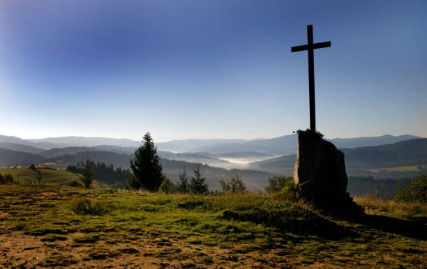 istock lonely cross under a mountain peak 1163015615