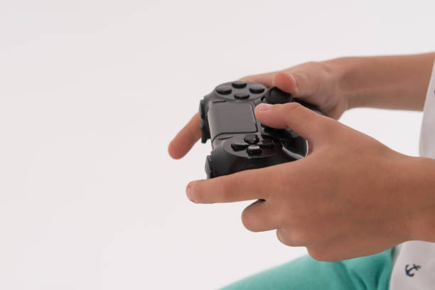 fermez-vous vers le haut de la main de garçon avec le pad de commande de jeu vidéo - video game joystick leisure games control photos et images de collection