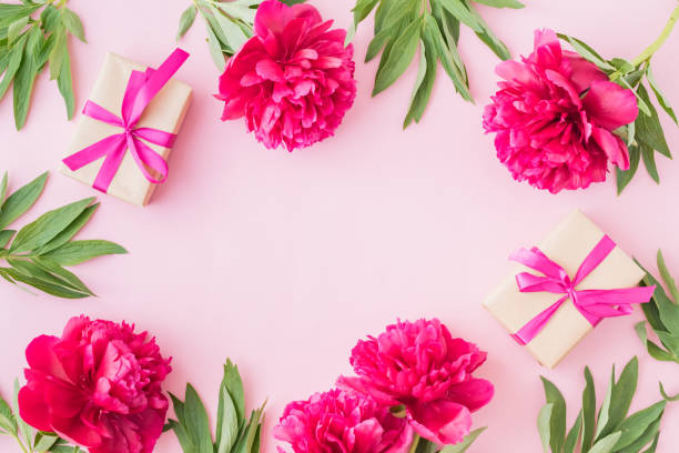 istock Flat lay composition with red peonies and gift box on a pink background 1163017970