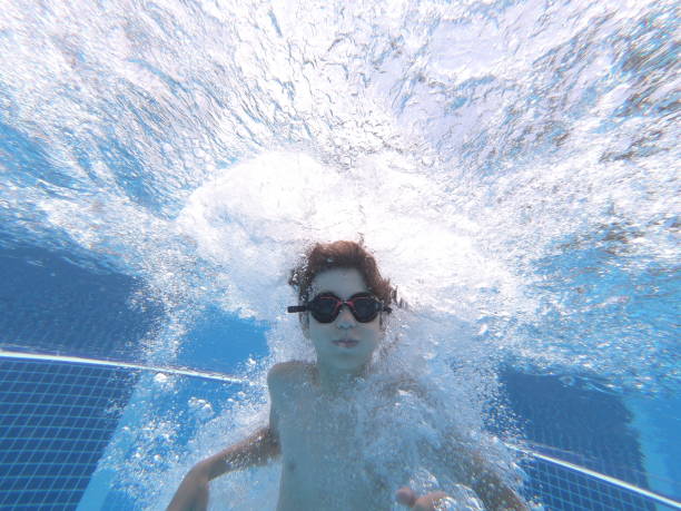 istock Happy boy jumped into swimming pool 1163018263