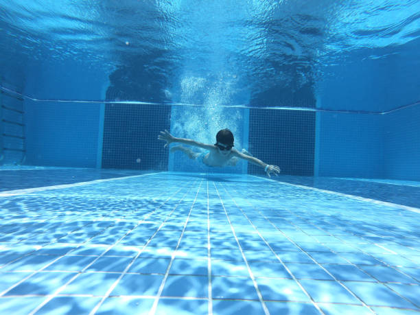 istock Happy boy jumped into swimming pool 1163018313