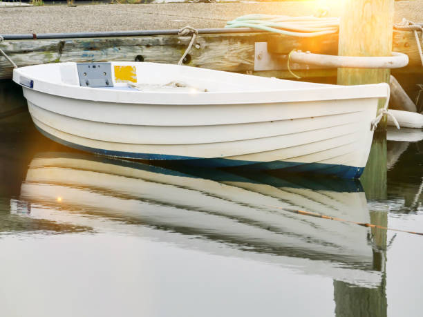 istock Little boat with sun beam and reflection on water 1163019414