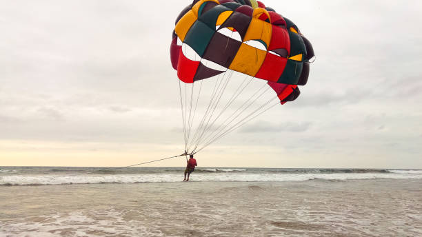 Parasailing extreme sports on the beach Parasailing extreme sports on the beach at sunset miami parachuting stock pictures, royalty-free photos & images