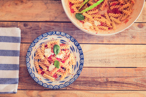 istock Simple pasta dish - fusilli in tomato sauce with mozzarella cheese and fresh basil leaves, close-up 1163025329