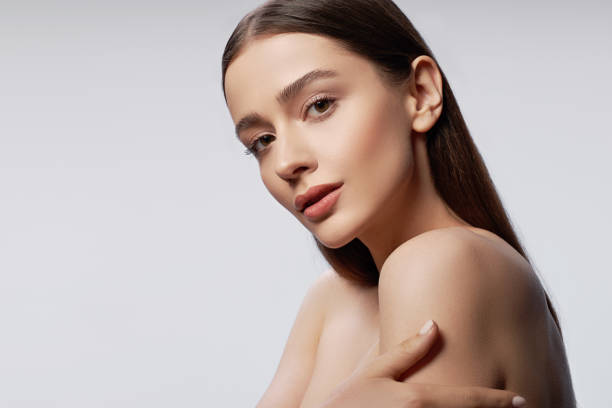 istock Young pretty lady with natural makeup posing against light gray background 1163030211