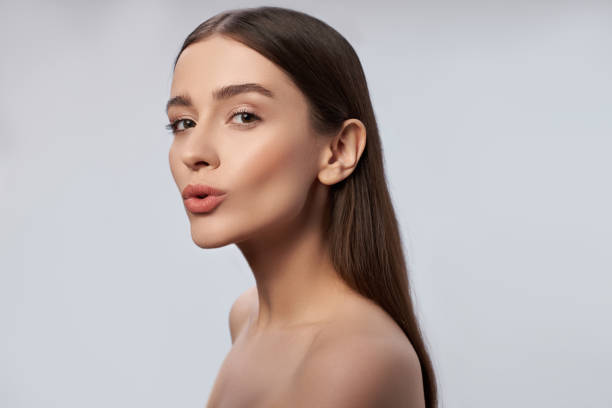 istock Attractive young lady with perfect skin standing against light gray background 1163030231